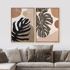 two paintings on the wall above a couch in a living room with pillows and throw pillows