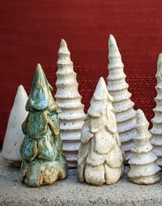 small ceramic christmas trees lined up in front of a red door