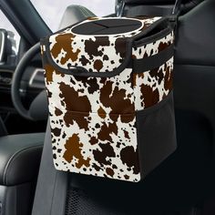 a brown and white animal print bag sitting on the back seat of a car