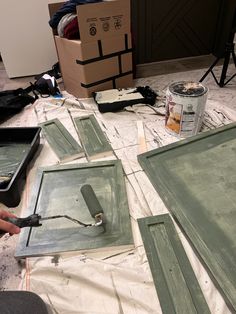 a person is painting some green doors on the floor