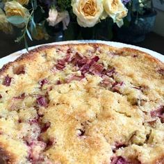 a close up of a pie on a plate with flowers in the backgroud