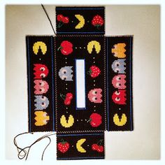 two pieces of knitted fabric with numbers and fruits on them, hanging from a wall