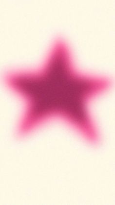 a blurry image of a pink star on a white background with the shadow of an object