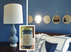 a bedroom with blue walls and white lamps on the nightstands in front of it