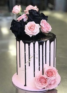 a black and white cake with pink roses on top