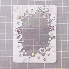 a white card with flowers, hearts and stars in the shape of a heart on it