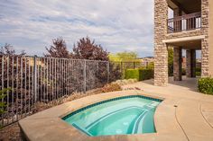 an empty swimming pool in front of a brick building with a balcony and balconies