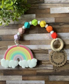 a wooden wall with a rainbow, cloud and keychain hanging from it's side