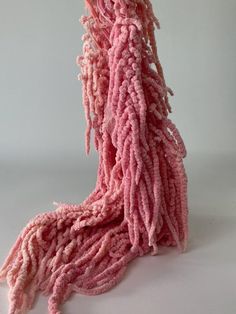 a pink mop is laying on top of a white surface with no one around it