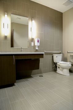 a bathroom with a toilet, sink and mirror