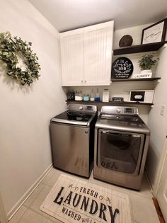 a washer and dryer in a small room with white cabinets on the wall