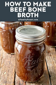 three jars filled with homemade beef bone broth sitting on top of a wooden table