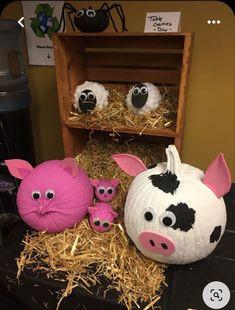 some fake farm animals are sitting in hay