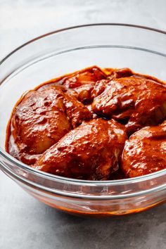 a glass bowl filled with meat covered in sauce