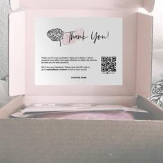 a pink box with a thank you card inside and qr code on the front