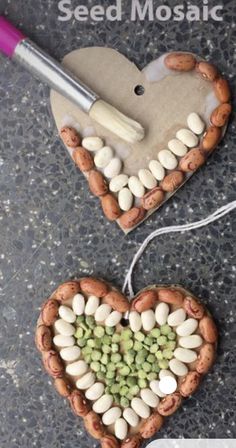 two heart shaped planters made out of peanuts and seed mosaics on a table