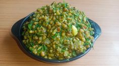 a bowl filled with green vegetables on top of a wooden table