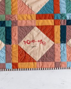 a close up of a patchwork quilt on a table top with the words purelook printed on it