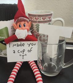 an elf is holding a sign that says i made you a cup of tea in it