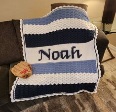 a crocheted blanket with the name noah on it is sitting on a couch