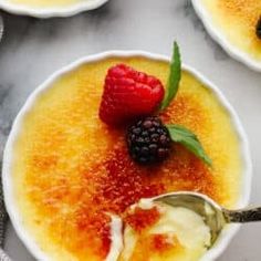 three bowls filled with dessert and topped with raspberries