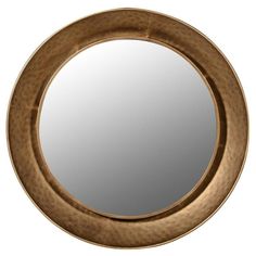 a round mirror sitting on top of a white wall