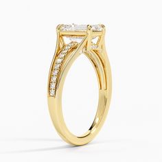 a yellow gold engagement ring with three stones on the side and an oval band around it