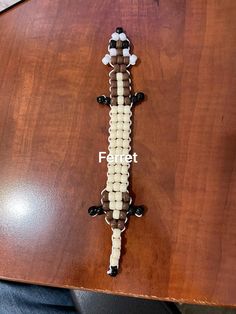 a wooden table topped with a beaded gecko