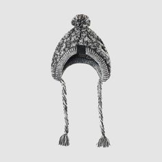 a black and white knitted hat with tassels