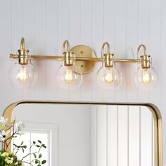 a bathroom vanity light with three bulbs on the side and a mirror in front of it