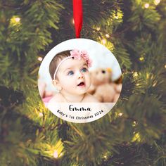 a baby's first christmas ornament hanging from a tree