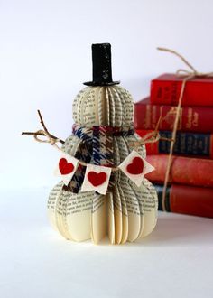 a snowman made out of book pages with a top hat and scarf on it