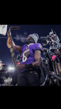 a football player is holding up his jersey