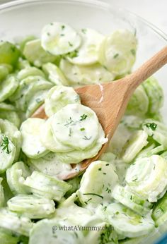 cucumber salad in a bowl with a wooden spoon and text overlay that reads quick & creamy cucumber salad