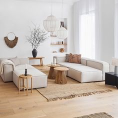 a living room filled with lots of furniture and decor on top of a hard wood floor