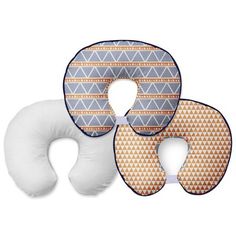 three neck pillows and one pillow with an orange pattern on the front, two are white