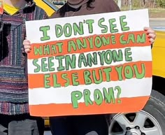 two people holding up a sign that says i don't see what anyone can see anymore else but you prom