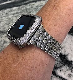 an apple watch on someone's arm with diamond bracelets and diamonds around it