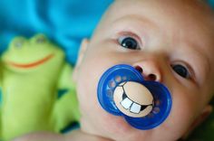 a close up of a baby with a pacifier in it's mouth,