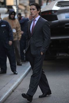 a man in a suit is walking down the street