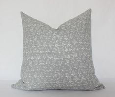 a gray and white pillow sitting on top of a table