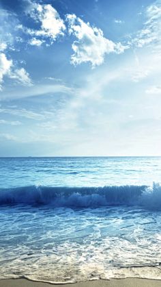 an ocean view with waves coming in to shore and blue sky above it, on a sunny day