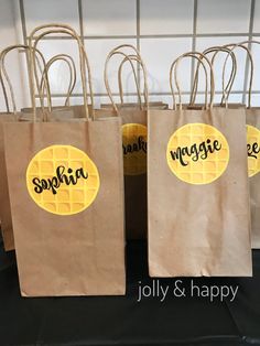 three brown paper bags with yellow waffles on them and the words spahria written in black