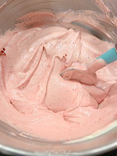 a bowl filled with pink and green food colorings on top of a white table