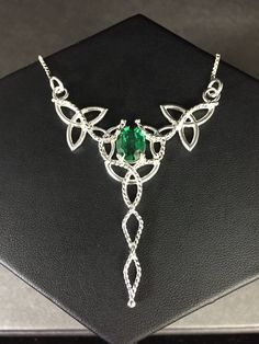 "I've designed this long, statement Celtic inspired necklace entirely in sterling silver featuring a center, faceted 10x8mm peridot gemstone! The frame, or centering, of the pendant is made with Celtic Trinity Knots and sterling wire work braids down the center to add the balancing touches to the piece. It comes with a sterling box chain which is soldered to each end of the pendant. This piece is 18\" in length, including the chain, and the pendant, itself, is approximately 3 inches, in height, May Birthstone Jewelry In Silver With Peridot, Silver Peridot Jewelry For May Birthstone, Silver Peridot Jewelry With Gemstone, Silver Peridot Jewelry For Anniversary, Silver Peridot Birthstone Jewelry, Formal Peridot Jewelry For May Birthstone, Silver Peridot Oval Jewelry, Silver Oval Peridot Jewelry, Sterling Silver Emerald Pendant Necklace For Wedding