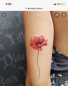 a woman's arm with a red flower tattoo on the left side of her arm