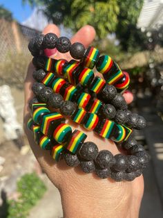 "These bracelets are a fun combination of round, squared and varied sized resin beads and black lava beads.. Resin beads are black with fun yellow, red and green stripes.  The variation of sizes makes them really unique and fun. Perfect for the lover of Rasta and all things Jamaica. Woman's wrist approx. 6\" ONLY AVAILABLE IN SIZE LISTED" Black Rectangular Beaded Bracelets For Gift, Rectangular Black Beaded Bracelets For Gifts, Multicolor Spiritual Bracelets With Black Beads, Adjustable Black Wristband With Colorful Beads, Black Wristband With Colorful Beads Gift, Handmade Black Lava Stone Beaded Bracelets, Black Wooden Beads Bracelet As Gift, Black Wooden Beaded Bracelets Gift, Adjustable Black Rectangular Beaded Bracelets