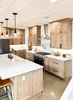 a large kitchen with wooden cabinets and white counter tops, an island in the middle