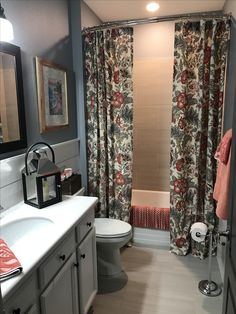 a bathroom with a toilet, sink and shower curtain in it's stall area