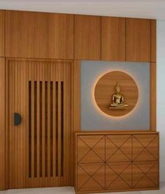 a room with a buddha statue on the wall next to a wooden cabinet and door